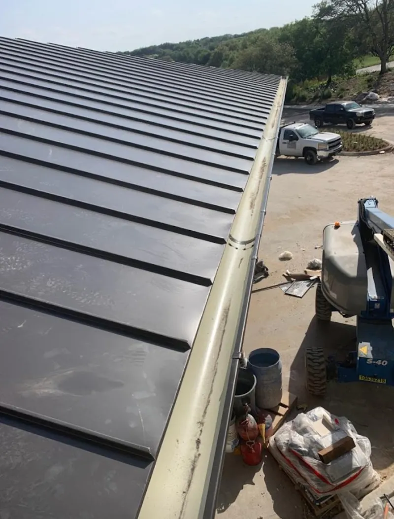 Standing seam panel and gutter detail on a metal roofing jobsite in Pennsville